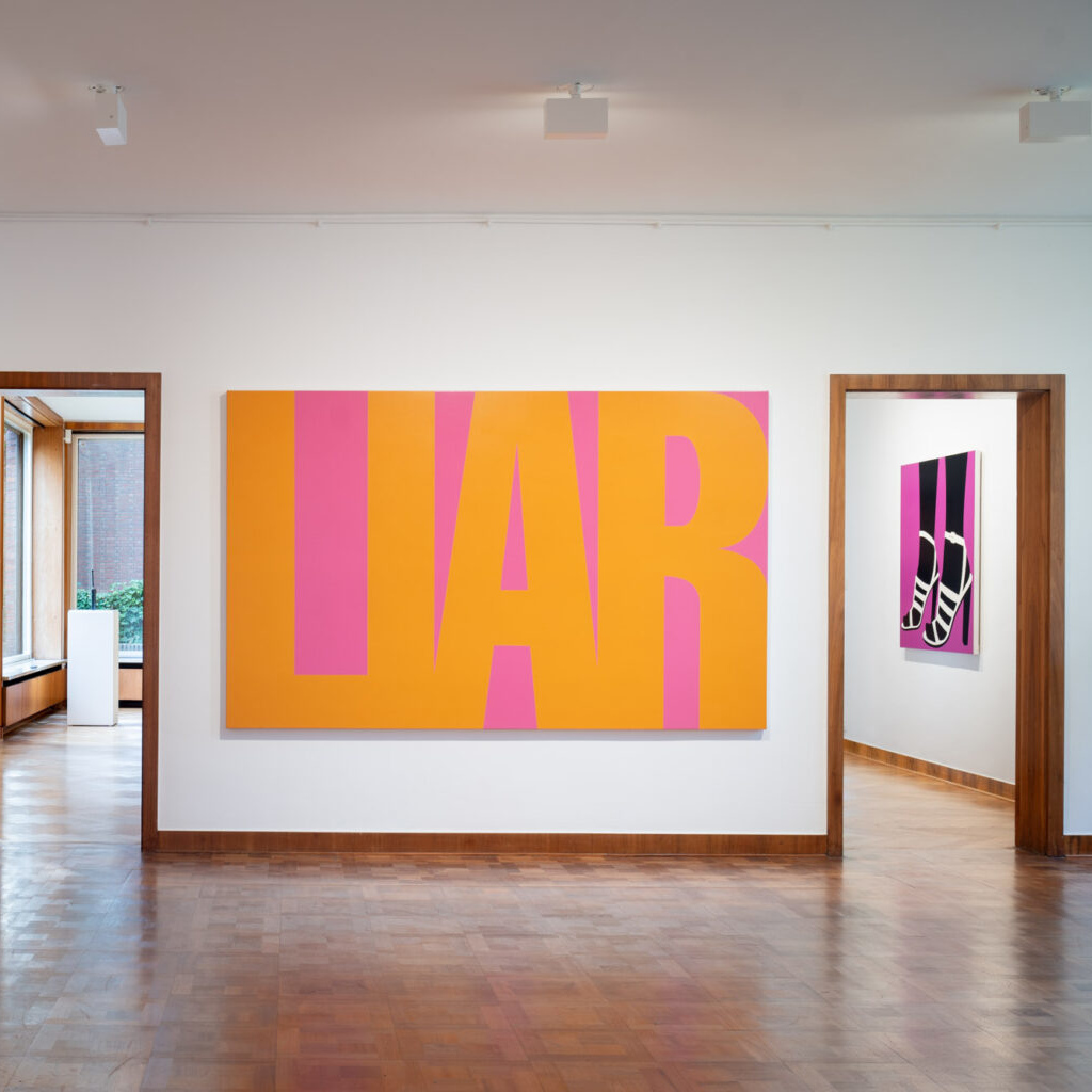 Foto von einer Kunstausstellung in einem White Cube. Zu sehen ist unter anderem das Gemälde „ Liar“ von Sarah Morris von 1995.