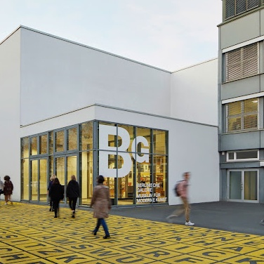 Berlinische Galerie Außen. Weißer Kastenbau. Davor gelbe Buchstaben auf dem Gehweg.