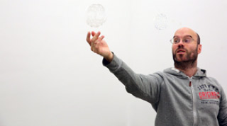 Das Foto zeigt den Künstler Julius Bockelt, wie er eine Seifenblase auffängt.