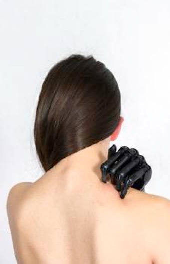 Oberkörper einer unbekleideten Frau mit einer schwarzen Handprotese auf der rechten Schulter